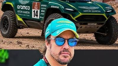 Fernando Alonso con casco y traje de piloto frente a un vehículo de rally en el desierto
