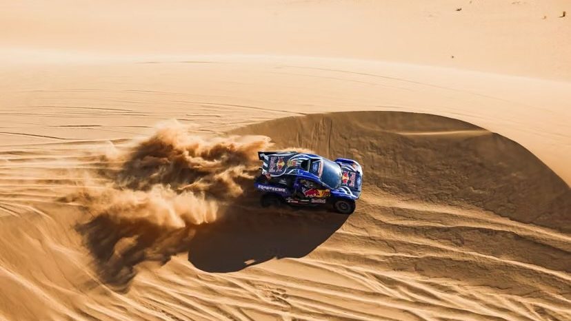 Vehículos del Rally Dakar compitiendo en dunas del desierto bajo el sol