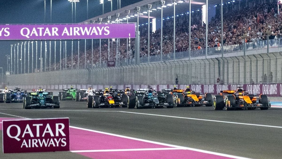 Monoplazas de Fórmula 1 en la largada de un Gran Premio con el pelotón compacto en curva