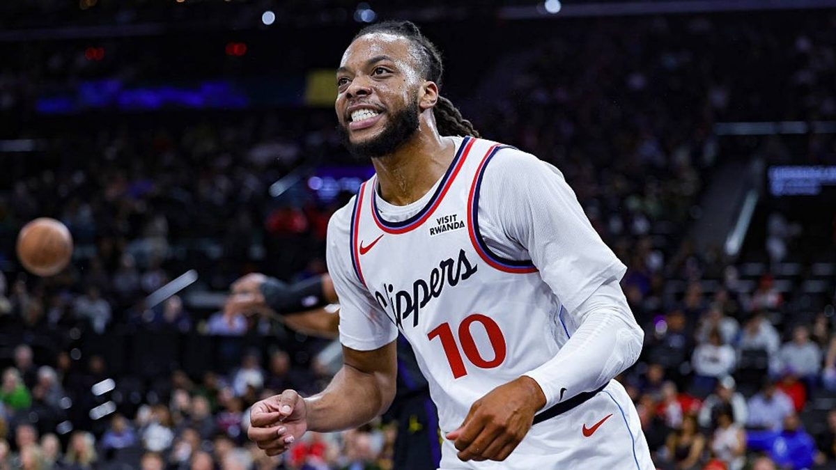 Jugadores de la NBA en cancha durante un partido de temporada regular con graderías llenas