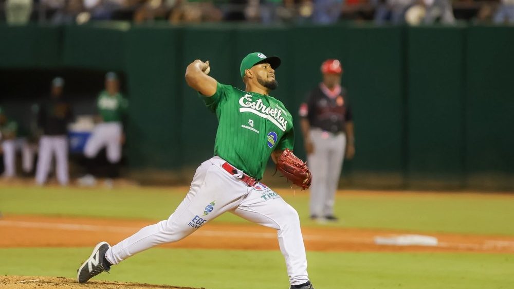 Óscar de la Cruz en posición de lanzamiento con el uniforme de las Estrellas Orientales en el béisbol dominicano