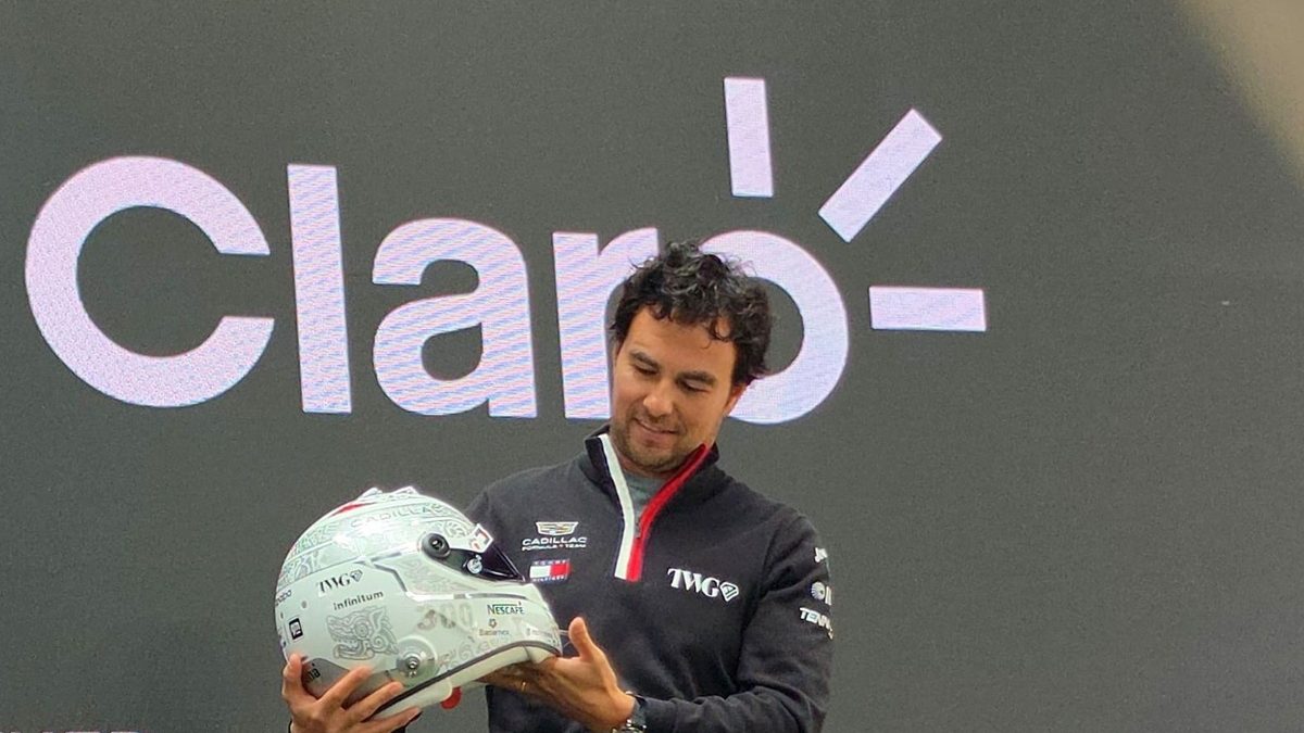 Sergio Checo Pérez sostiene su casco especial con diseño prehispánico para las 300 carreras en F1 en el GP de México