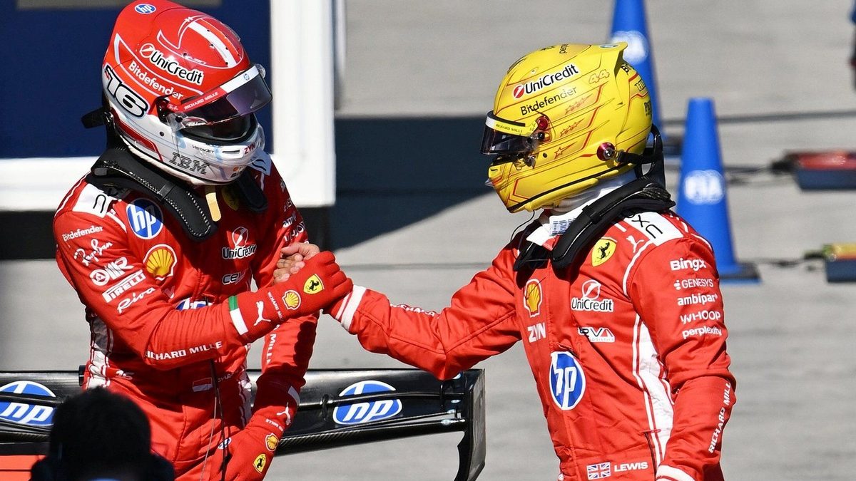 Lewis Hamilton y Charles Leclerc con el uniforme de Ferrari en el paddock de Fórmula 1