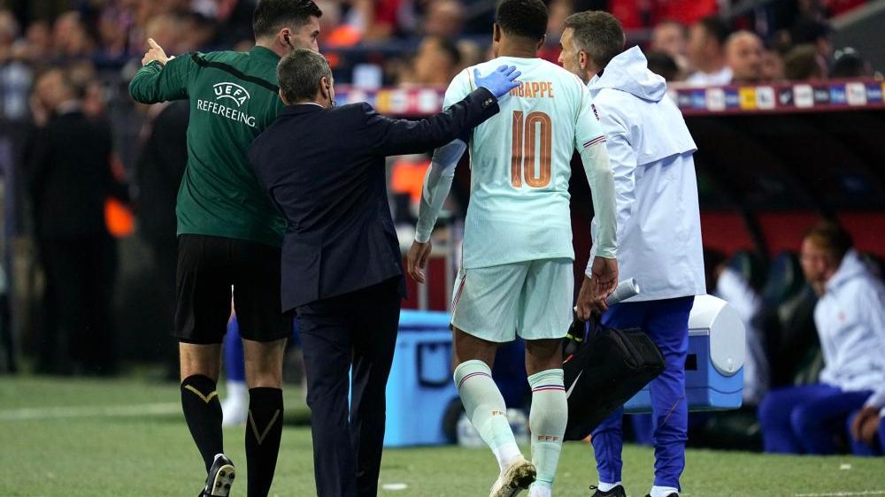 Kylian Mbappé sujetándose la rodilla izquierda en el campo durante el partido Francia vs Turquía en la Liga de Naciones