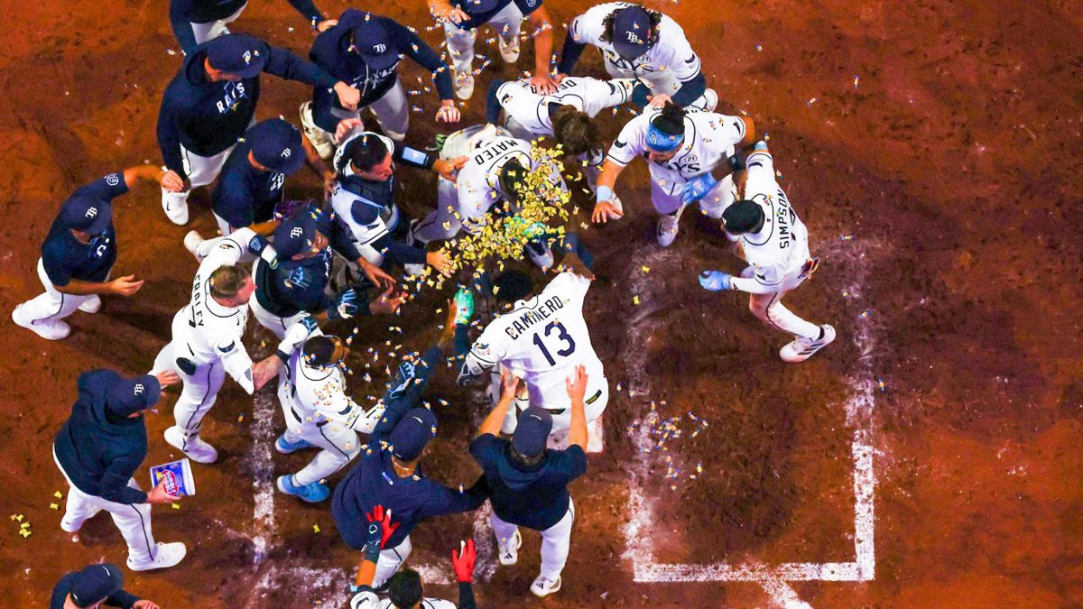 Junior Caminero celebra su jonrón walk-off número 41 rodeado por sus compañeros de los Tampa Bay Rays