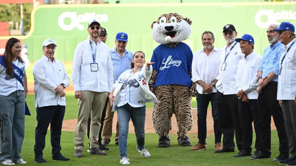 Embajadora Leah Francis Campos realizando el lanzamiento ceremonial de la primera bola en el estadio antes del partido Licey vs. Escogido