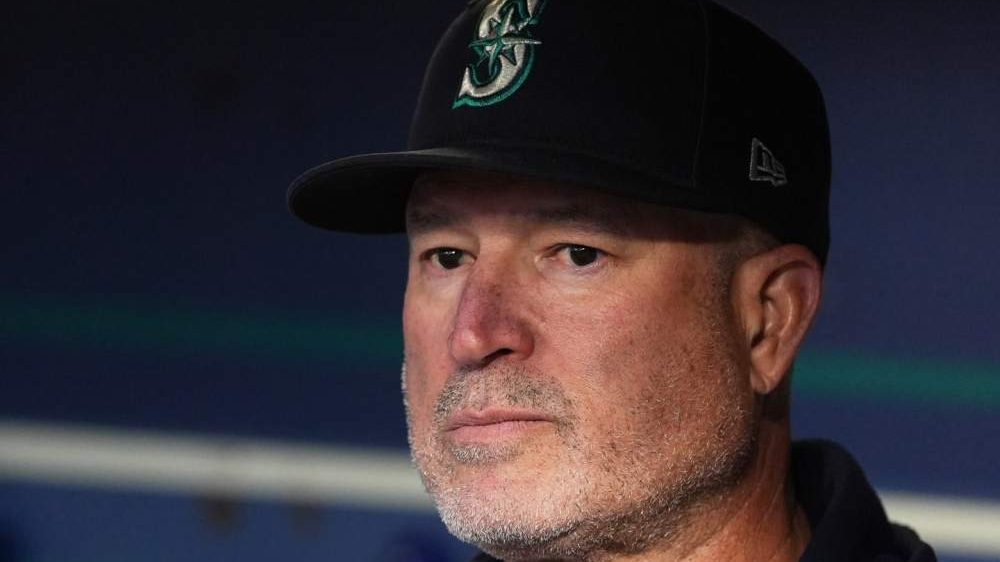 Manny Acta en el dugout de los Marineros de Seattle durante un partido de MLB