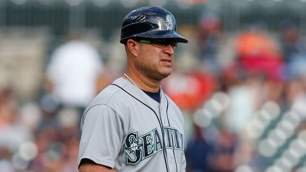 Manny Acta en el dugout de los Marineros de Seattle durante un partido de la MLB