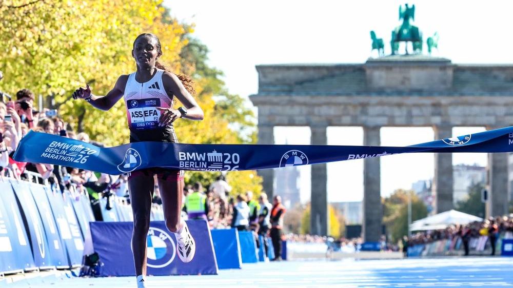 Guye Adola cruzando la meta del maratón de Berlín 2026 con el brazo en alto