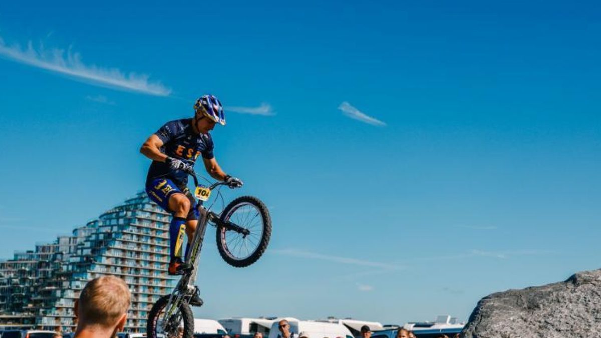 Ciclista de BMX Freestyle realizando un truco en competencia internacional, con el logo de la UCI al fondo