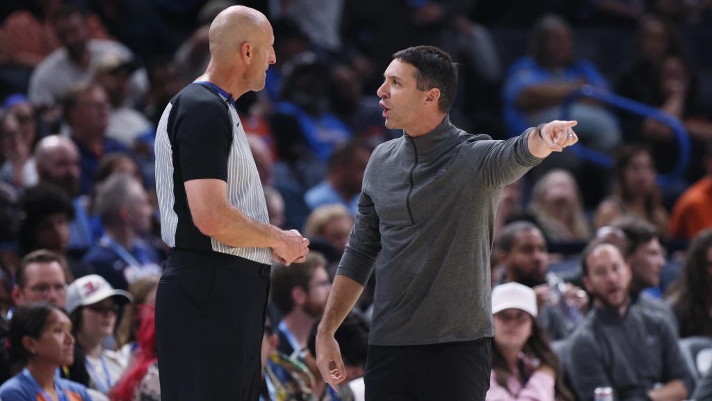 Árbitro de la NBA señalando una falta técnica a un jugador durante un partido de baloncesto