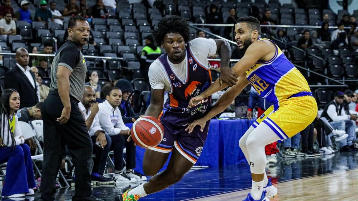 Jugadores de baloncesto disputando un partido en la Arena BanReservas durante el TBS Distrito 2026