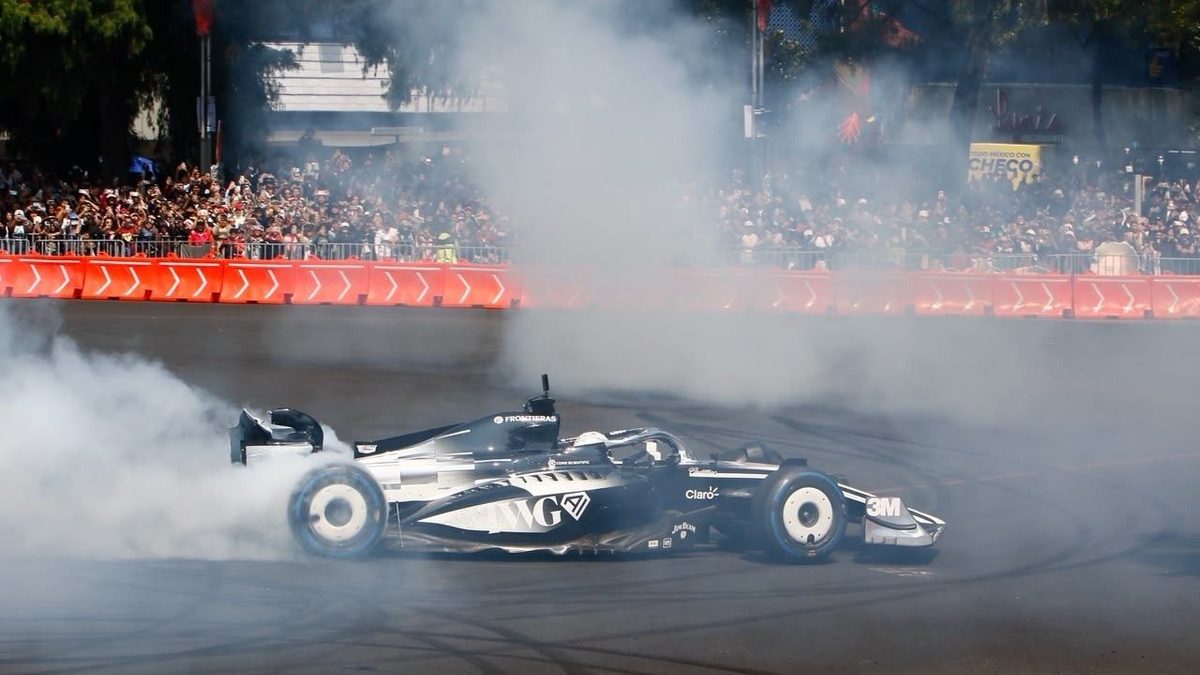 Checo Pérez realizando donas con el monoplaza de Cadillac F1 en el Paseo de la Reforma frente al Ángel de la Independencia