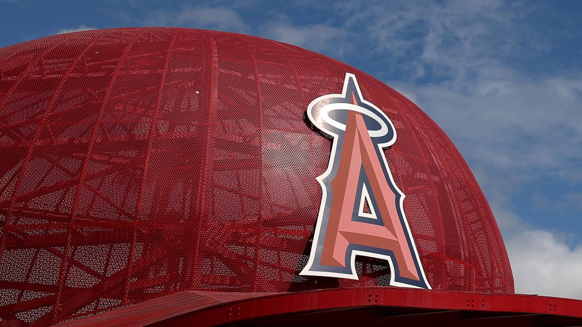 Stan Kroenke, nuevo dueño de los Los Angeles Angels, junto al logo de la franquicia de la MLB