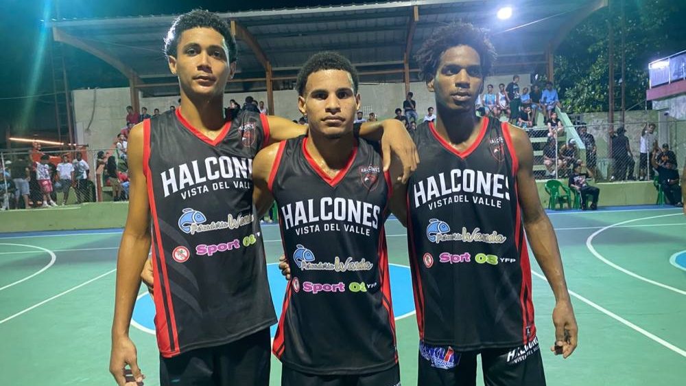 Jugadores de baloncesto disputando un partido nocturno en la cancha de la comunidad de Madeja