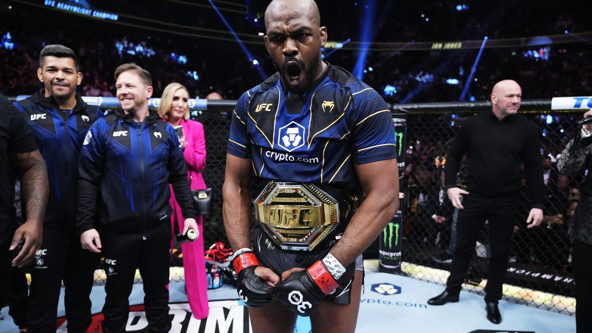 Jon Jones posa con el cinturón de campeón de los pesos pesados de UFC frente al octágono